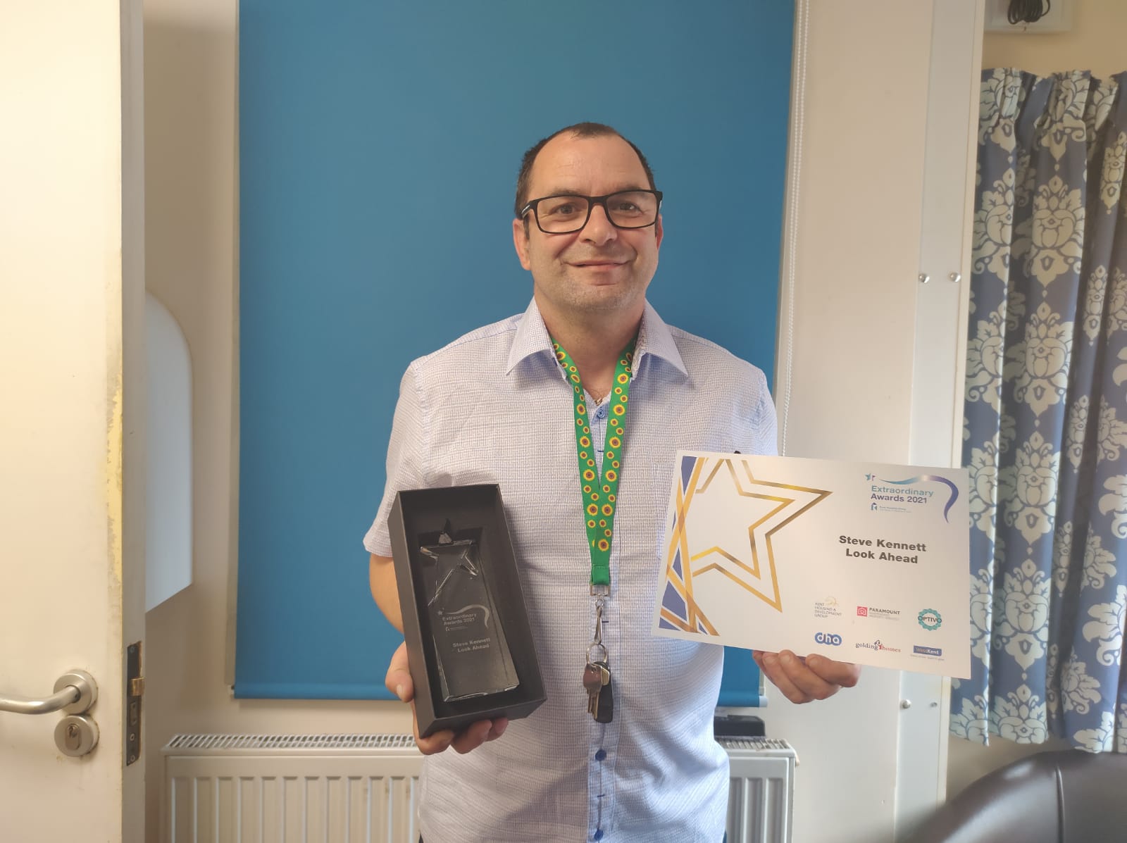 Man standing holding an award